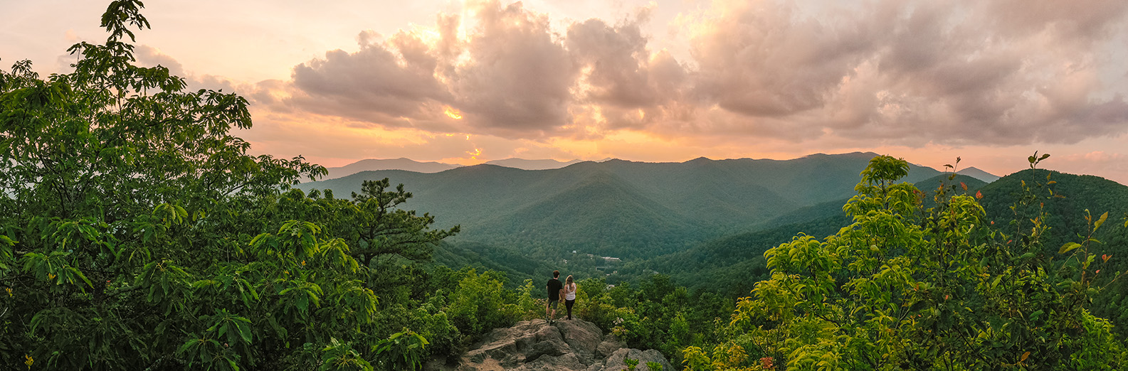 a couple overlooking a mountain sunset wearing performance apparel for any adventure